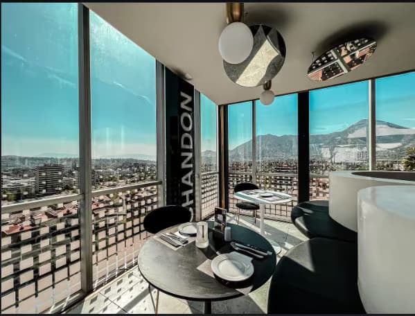 Comedor panorámico terminado junto a un ventanal de piso a cielo.